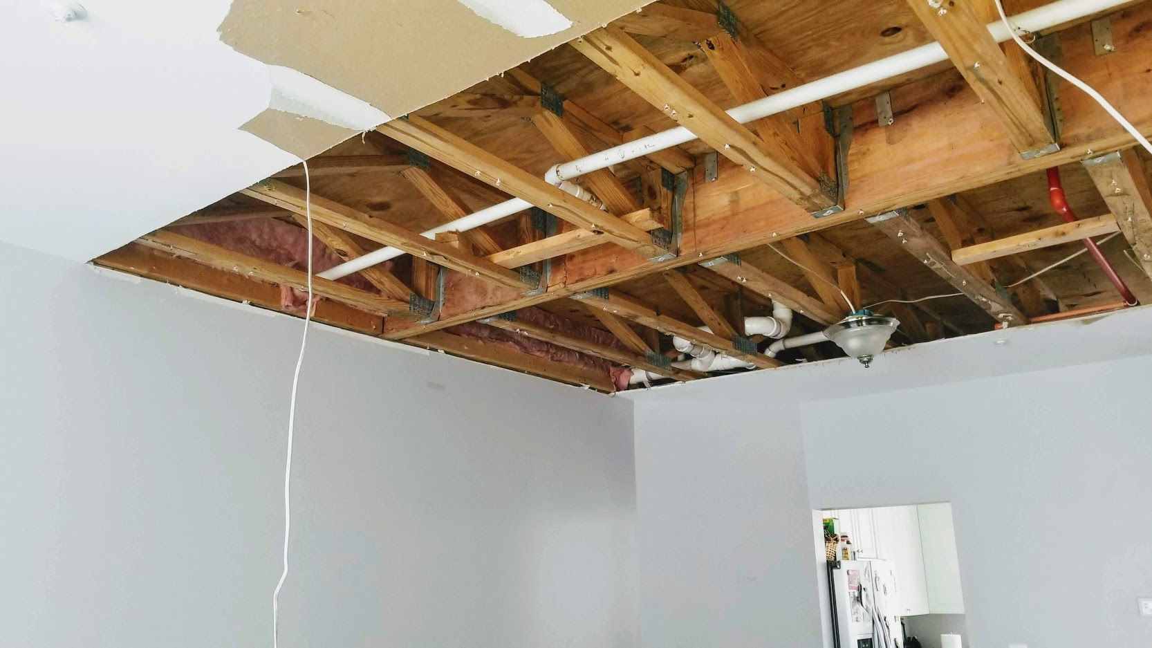 Large drywall ceiling cut for leak repair in a living room, showing a significant section needing replacement, with surrounding walls also requiring repainting in Upper Marlboro, MD, US.