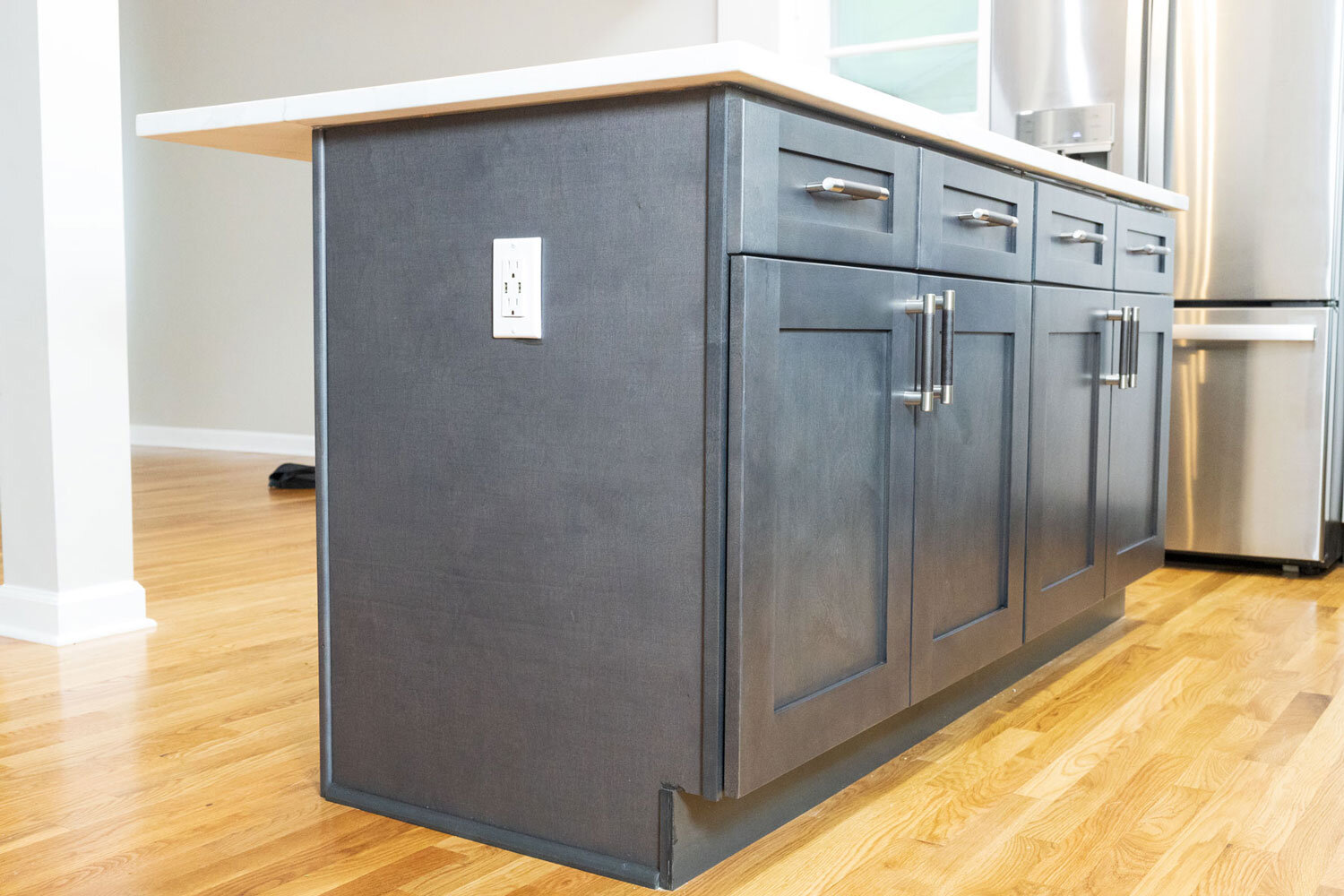Home remodeling contractor: Photo of a beautifully remodeled kitchen island in Capitol Heights, Maryland. It showcases Calacatta Storm Quartz countertops and Graystone Shaker cabinets, creating a stylish and functional space.