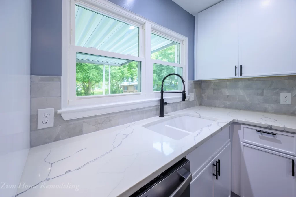After photo of kitchen countertop with white quartz sink, Delta Antoni faucet, backsplash tile, and MSI quartz, a complete kitchen remodel project by your next kitchen remodeling specialists in Prince George's County, MD, US.