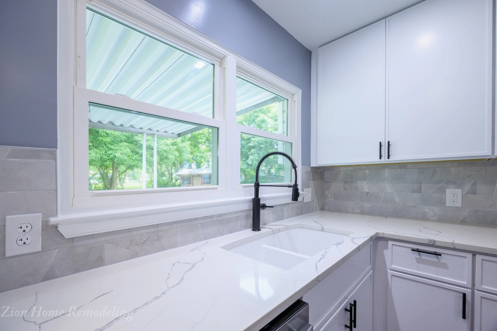 After picture showing MSI Statuary Classique quartz countertop, white undermount sink, backsplash tile, faucet, and slim shaker cabinets, for a complete kitchen renovation by Zion Home Remodeling, a licensed kitchen contractor serving Clinton, MD, US.